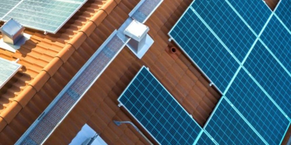 top-view-blue-solar-photo-voltaic-panels-system-apartment-building-roof-top-scaled