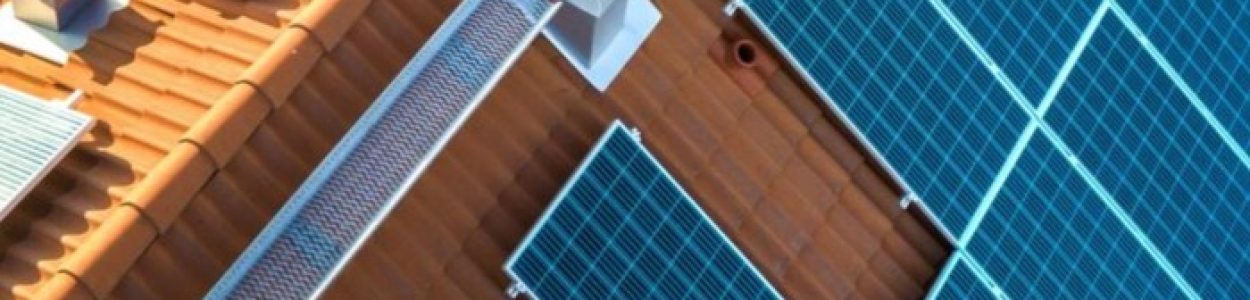 top-view-blue-solar-photo-voltaic-panels-system-apartment-building-roof-top-scaled